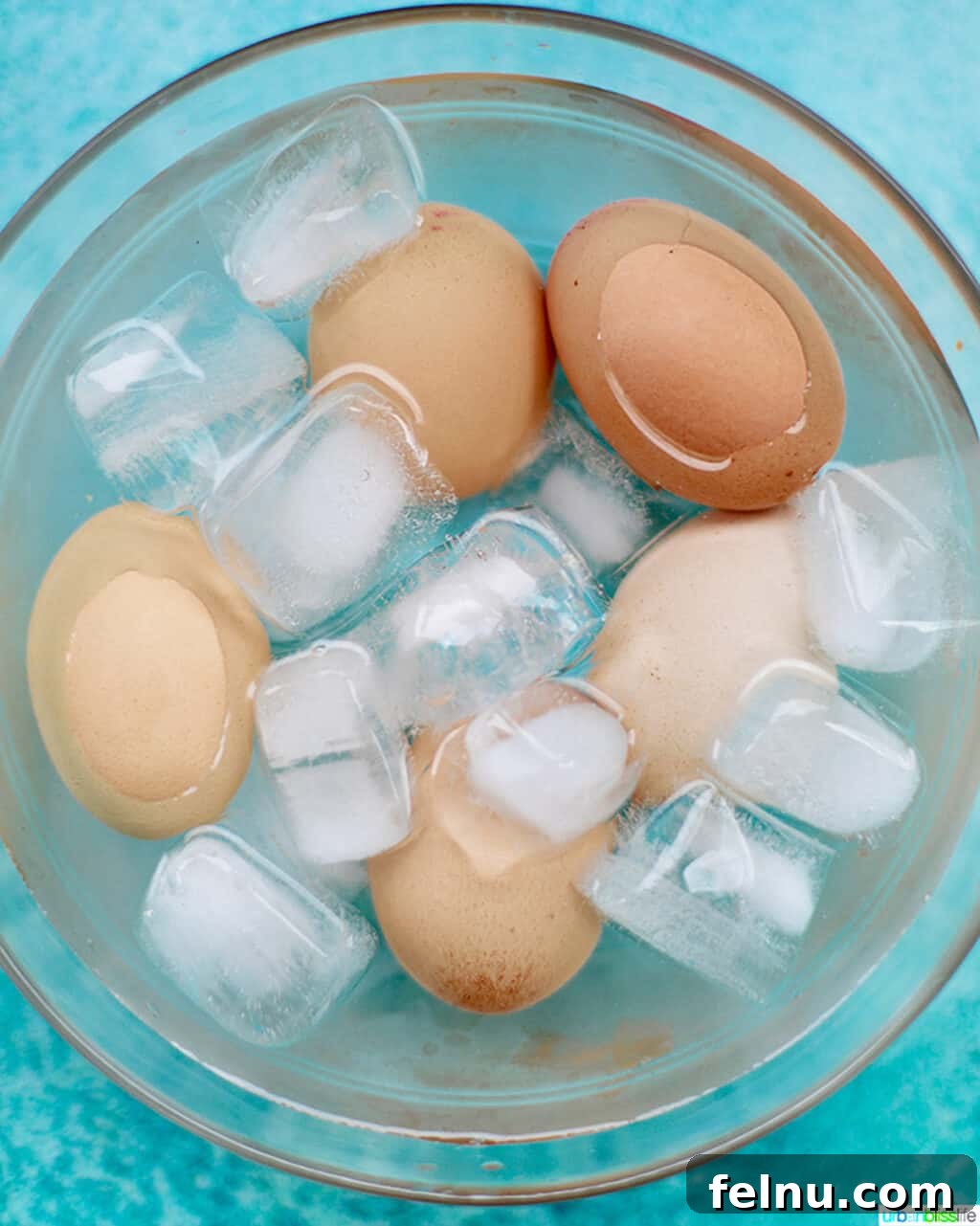 Perfect Hard Boiled Eggs with Ninja Foodi 7 Hard-boiled eggs resting in an ice bath to cool down and stop cooking