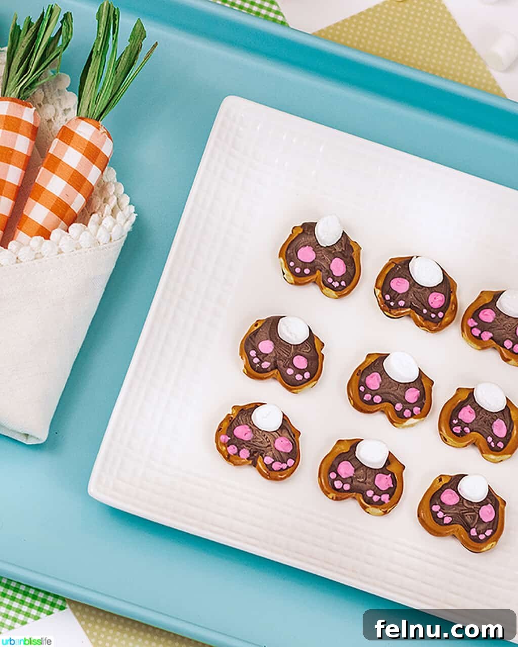Whip Up Adorable Easter Bunny Pretzels 2 Cute Easter Bunny Pretzels arranged on a light blue serving tray, showcasing their adorable marshmallow tails and pink paw details.