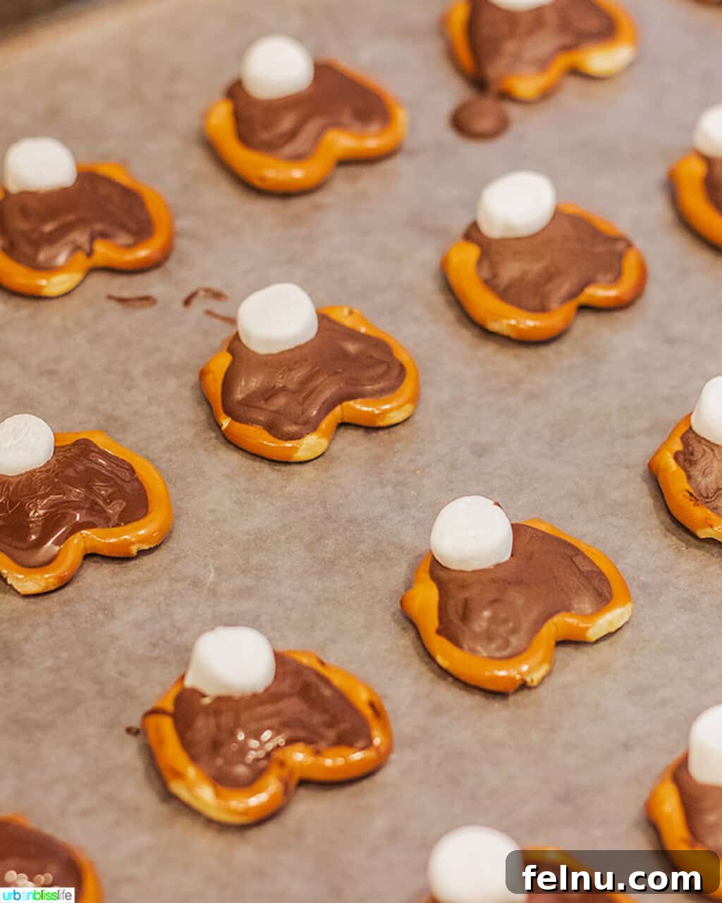 Whip Up Adorable Easter Bunny Pretzels 7 A close-up of bunny pretzels with marshmallow halves placed on top of the chocolate as tails, before setting.