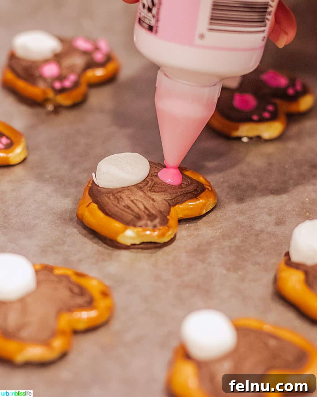 Whip Up Adorable Easter Bunny Pretzels 8 A finished Easter bunny pretzel with a fluffy white marshmallow tail and delicate pink icing paws piped onto the chocolate.
