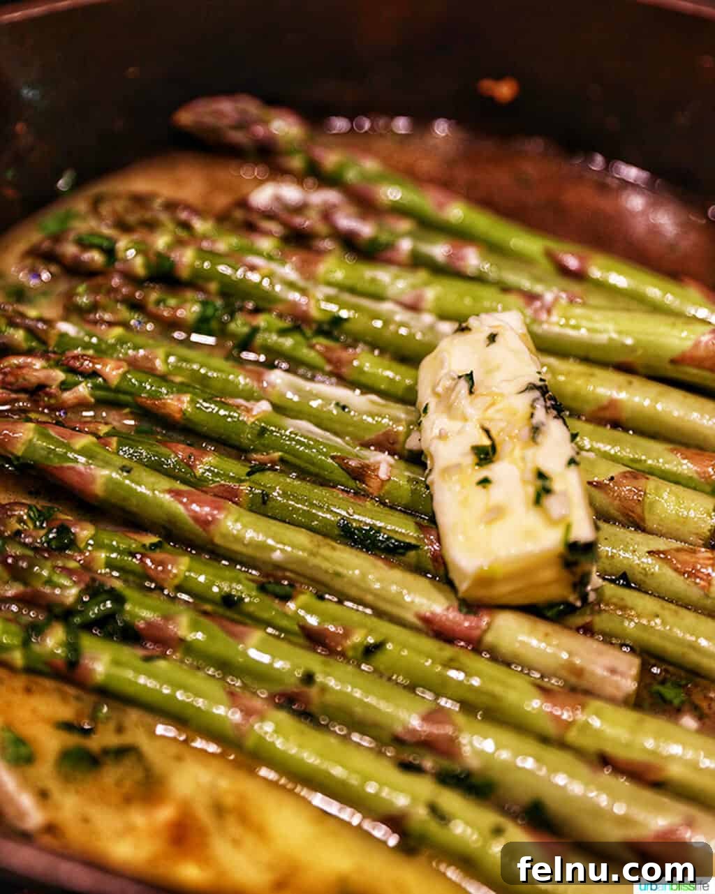 Golden Garlic Butter Chicken Morsels 8 Butter melting over asparagus in a hot skillet
