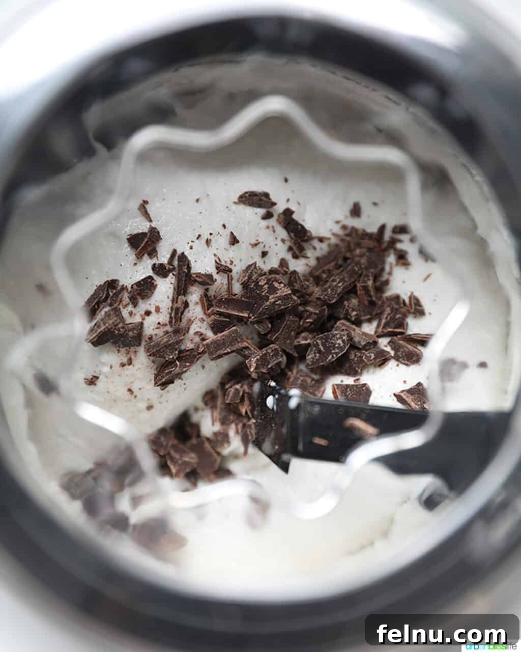 Decadent Dairy-Free Chocolate Chip Delight 7 Dairy-free ice cream churning in the ice cream maker with chocolate chips being incorporated.
