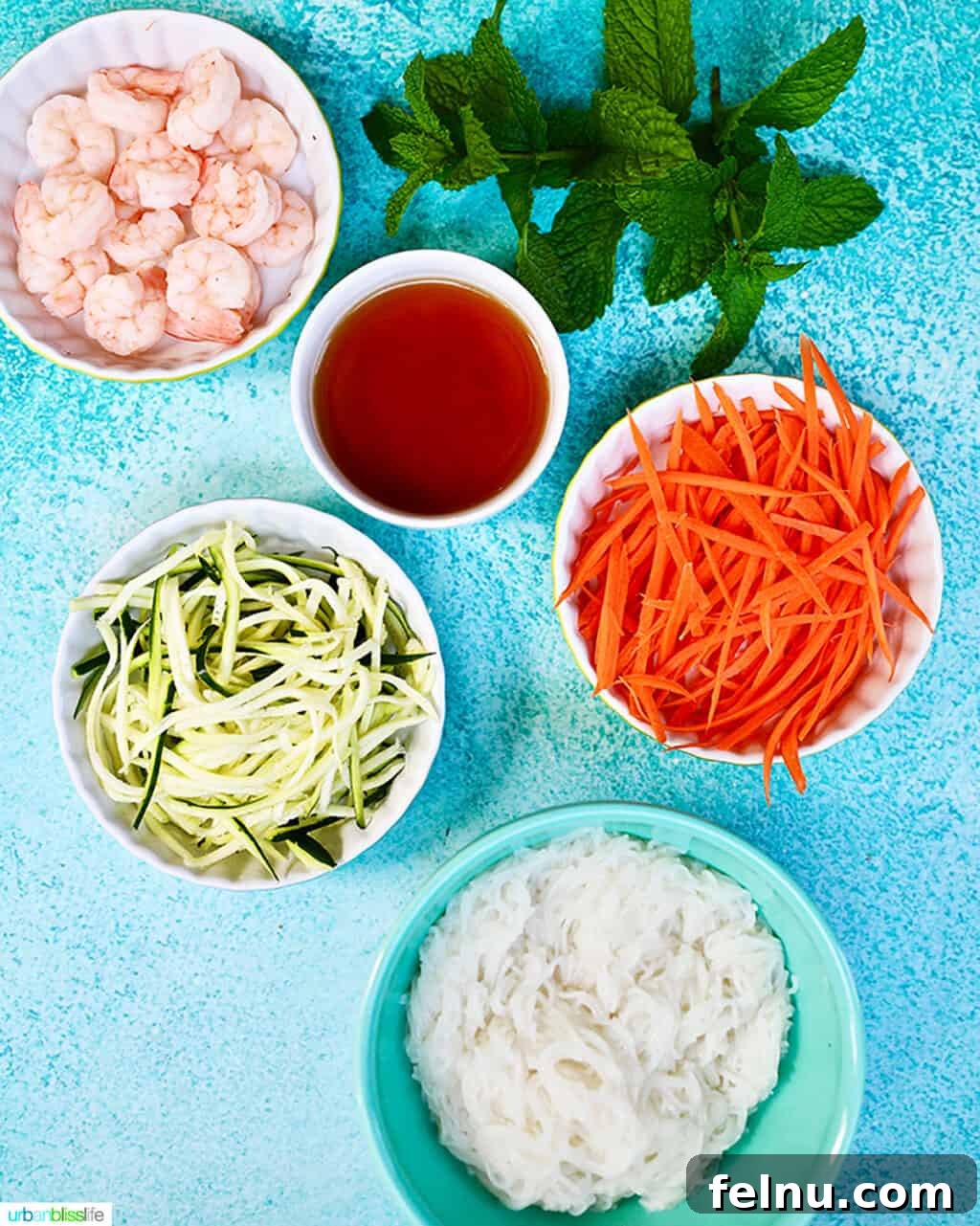 Ingredients laid out for making shrimp summer rolls: shrimp, noodles, rice paper, and various vegetables.