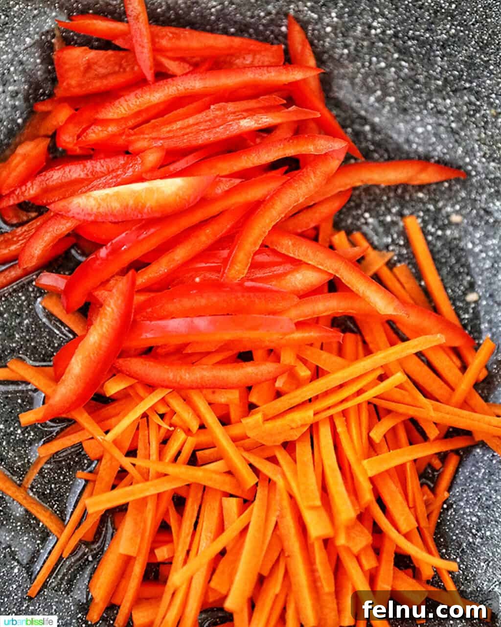 Filipino Pancit Bihon Delight 8 Stir-frying carrots and red peppers for Filipino Pancit Bihon.