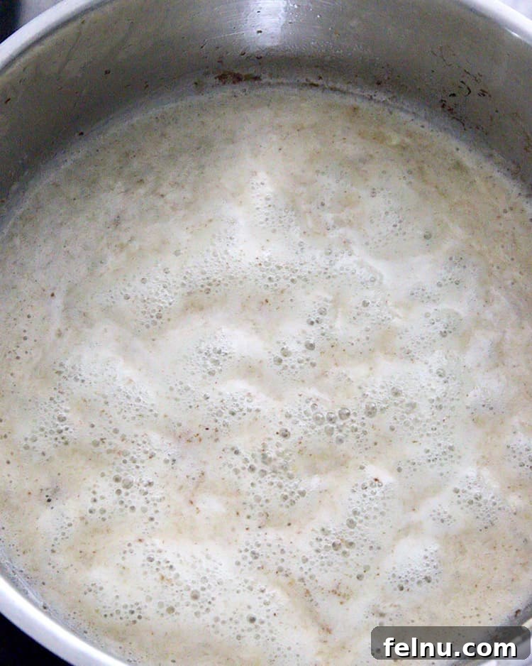 Creamy Bacon & Pea Pasta (Dairy-Optional) 7 Dairy-free cream sauce bubbling on the stovetop