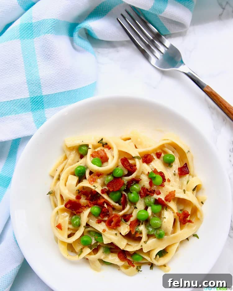 Creamy Bacon & Pea Pasta (Dairy-Optional) 8 A single bowl of Dairy-Free Fettuccine with Bacon and Peas with a fork