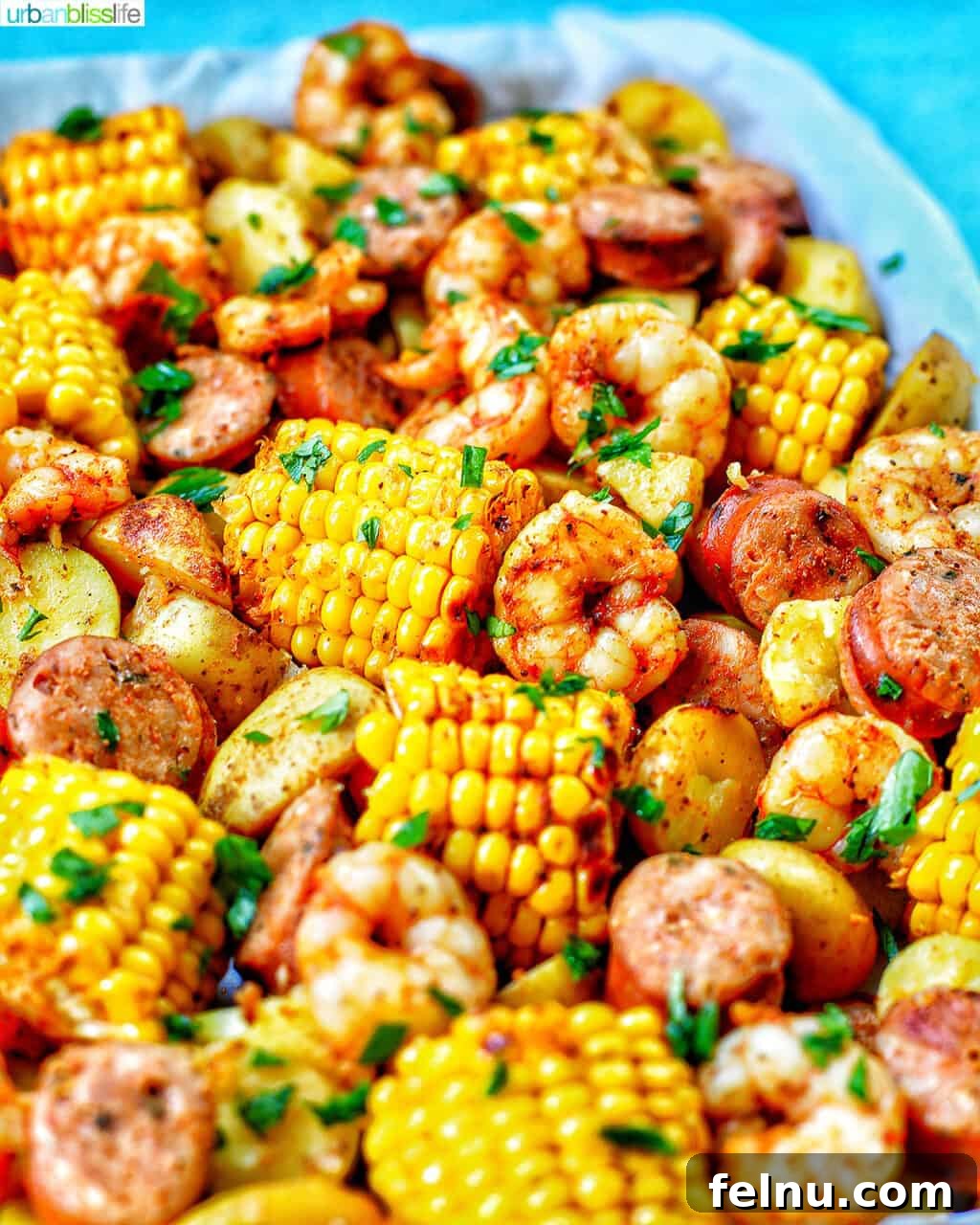 Folyoda Deniz Mahsulleri Şöleni 7 tray of seafood, corn, sausage low country boil with blue background