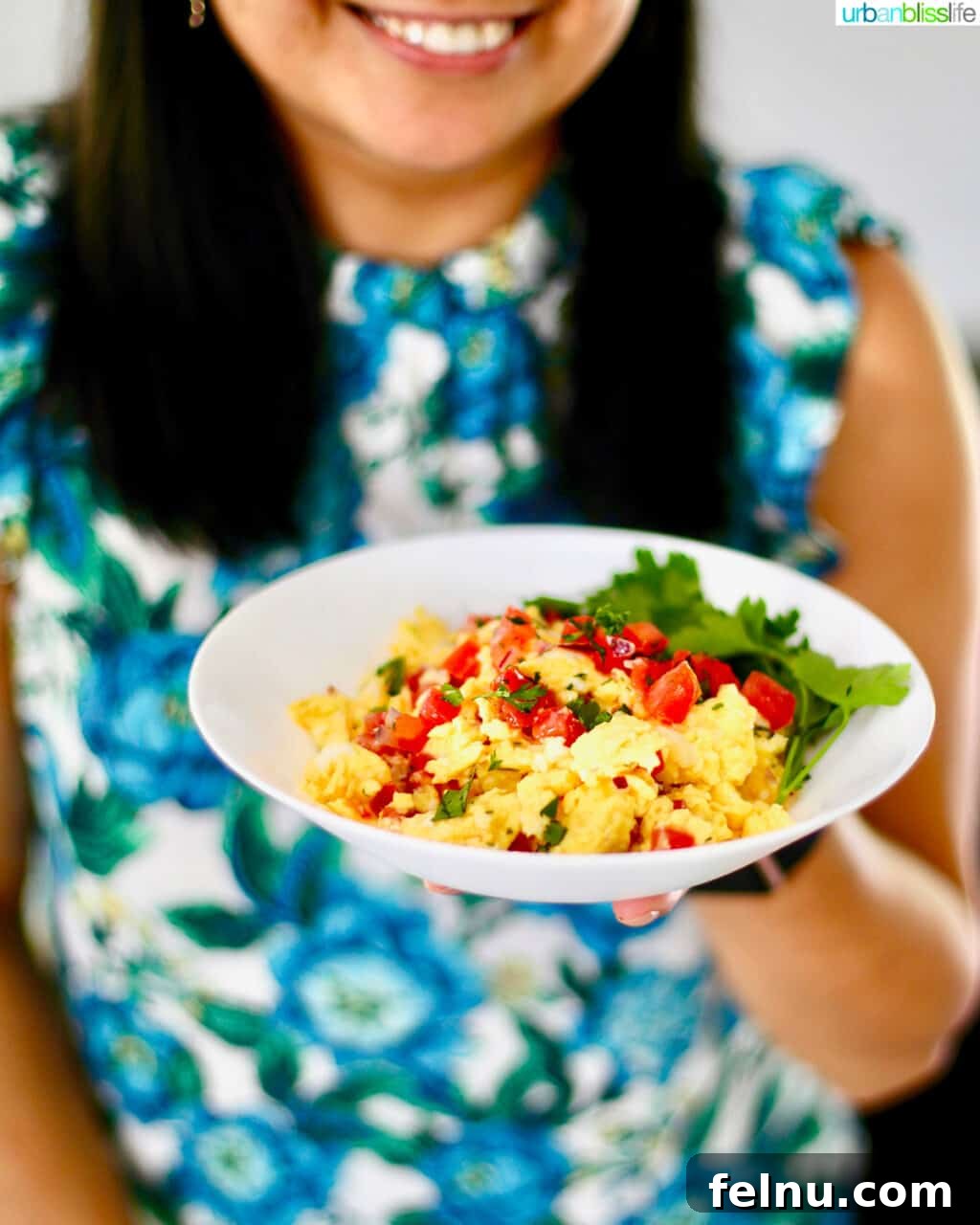 Fiesta Eggs 3 holding bowl of salsa eggs against backdrop of blue and white floral shirt