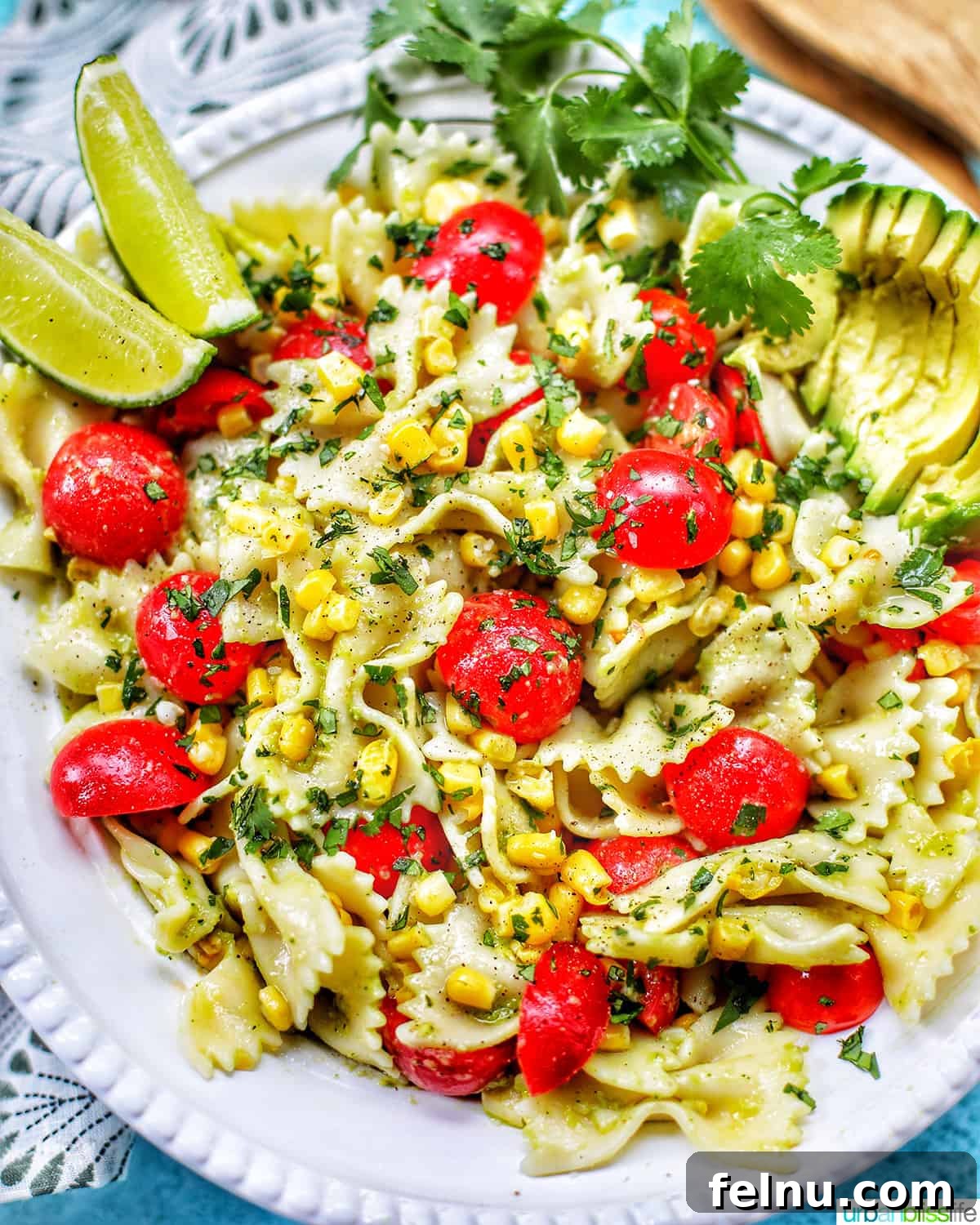 Close-up of Avocado Pasta Salad with Tomatoes and Corn, showing the creamy sauce and vibrant colors.