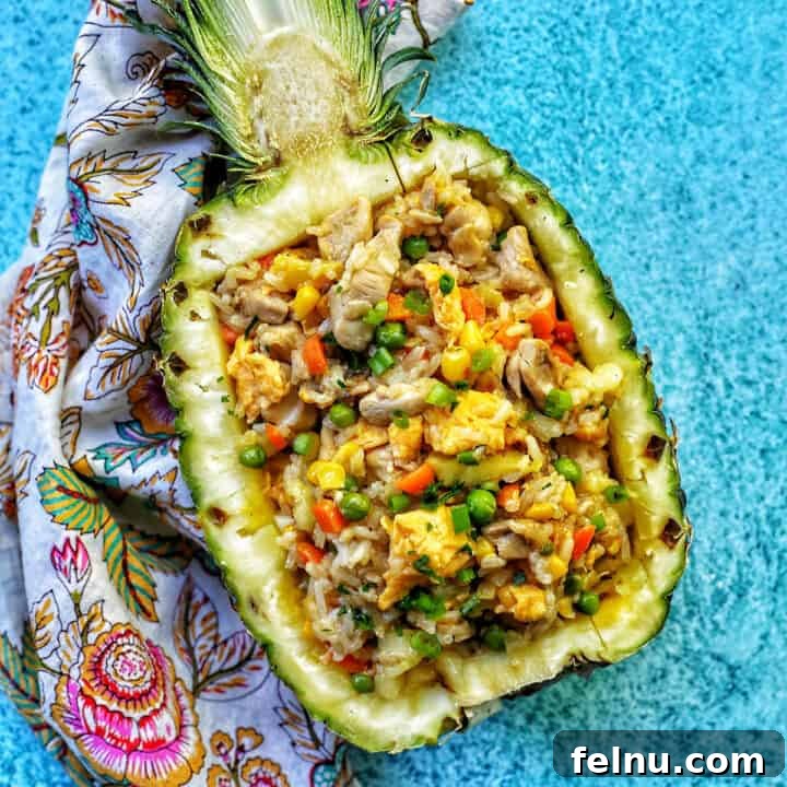 fried rice sitting in a hollowed out pineapple half.