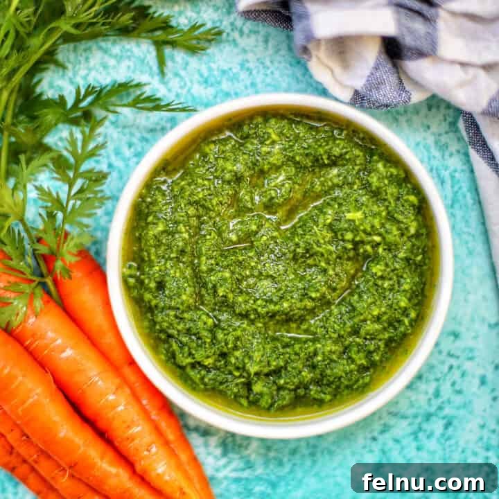 carrot top pesto in a bowl with carrots