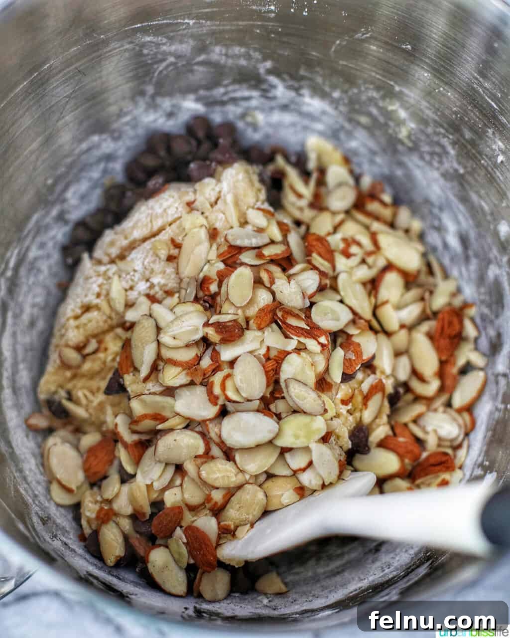 Toasted Almond Chocolate Chip Biscotti 8 adding sliced almonds to the biscotti batter with a spatula