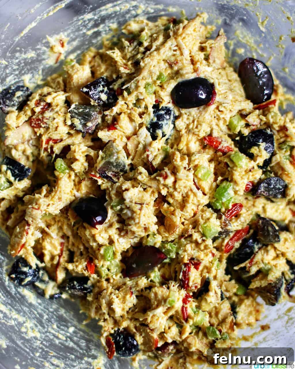 Golden Curry Chicken Salad with Grapes 6 A large bowl filled with perfectly mixed curry chicken salad, showcasing the harmonious blend of chicken, grapes, almonds, and creamy curry dressing.