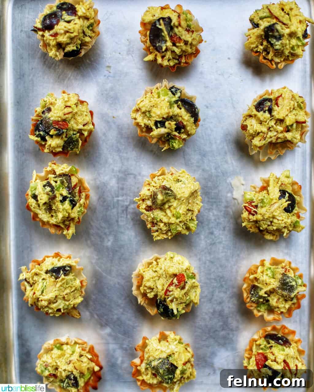 Golden Curry Chicken Salad with Grapes 8 Curry chicken salad phyllo dough appetizer bites arranged neatly on a parchment-lined baking sheet, ready for a quick bake.