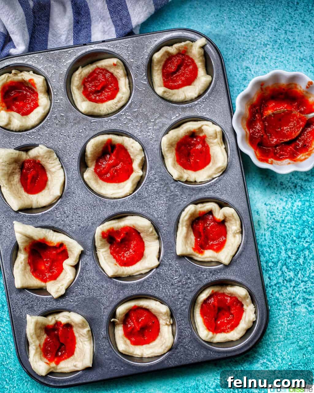 Effortless Pizza Bites 7 Adding Pizza Sauce to Pizza Crust in Muffin Tins