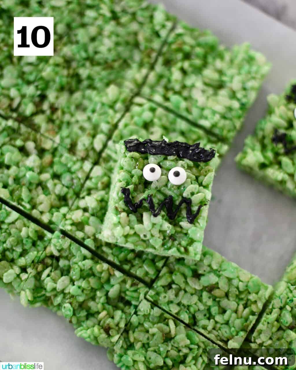Frankenstein's Monster Munch 14 A fully decorated Frankenstein Rice Krispie treat, with candy eyes and black icing features, resting on a stack of undecorated treats.