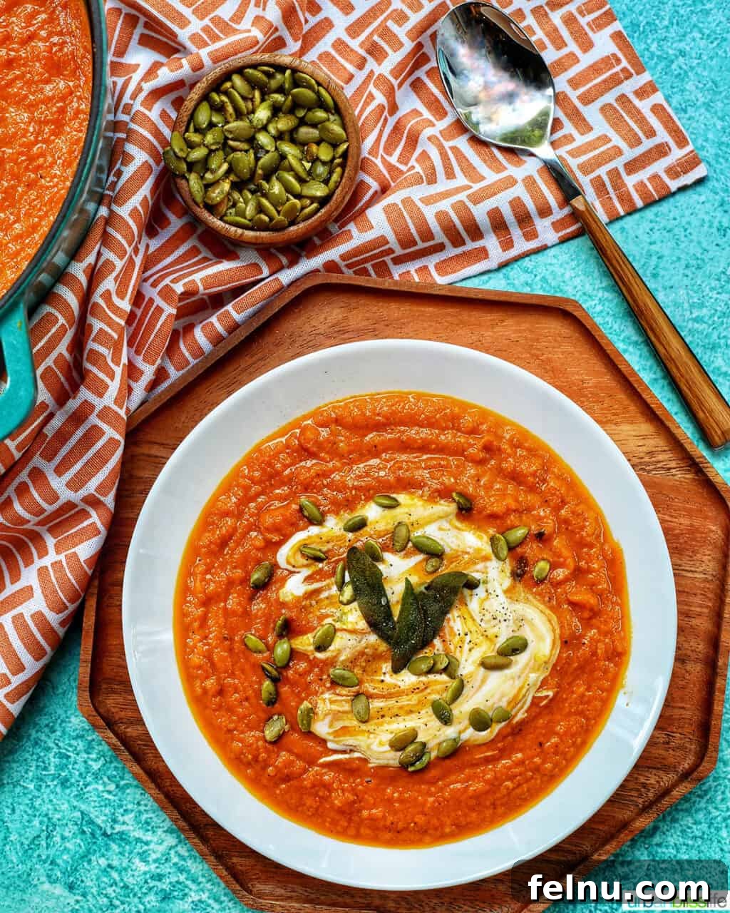 A bowl of creamy vegan pumpkin soup without cream, garnished with pumpkin seeds, ready to be enjoyed.