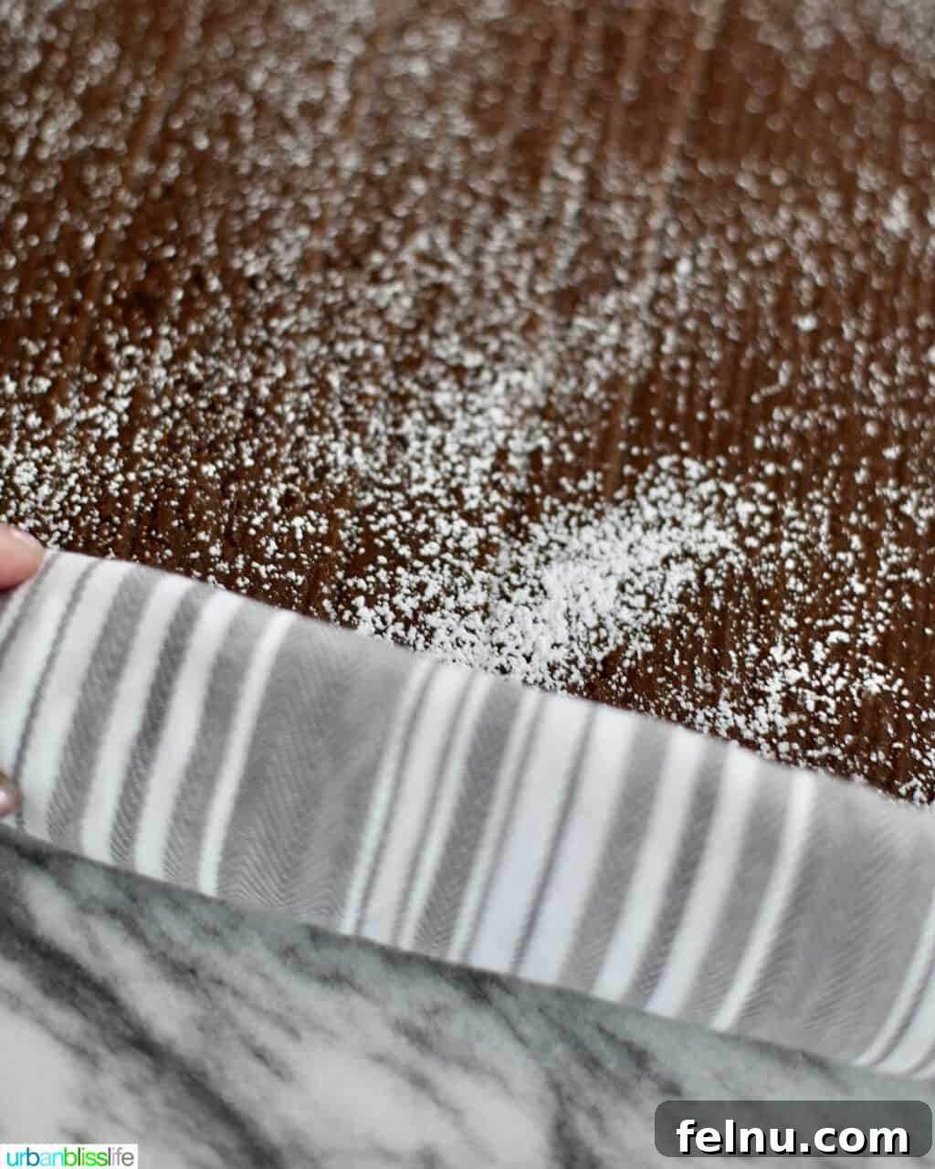 Rolling up the gingerbread cake roll layer with parchment paper.