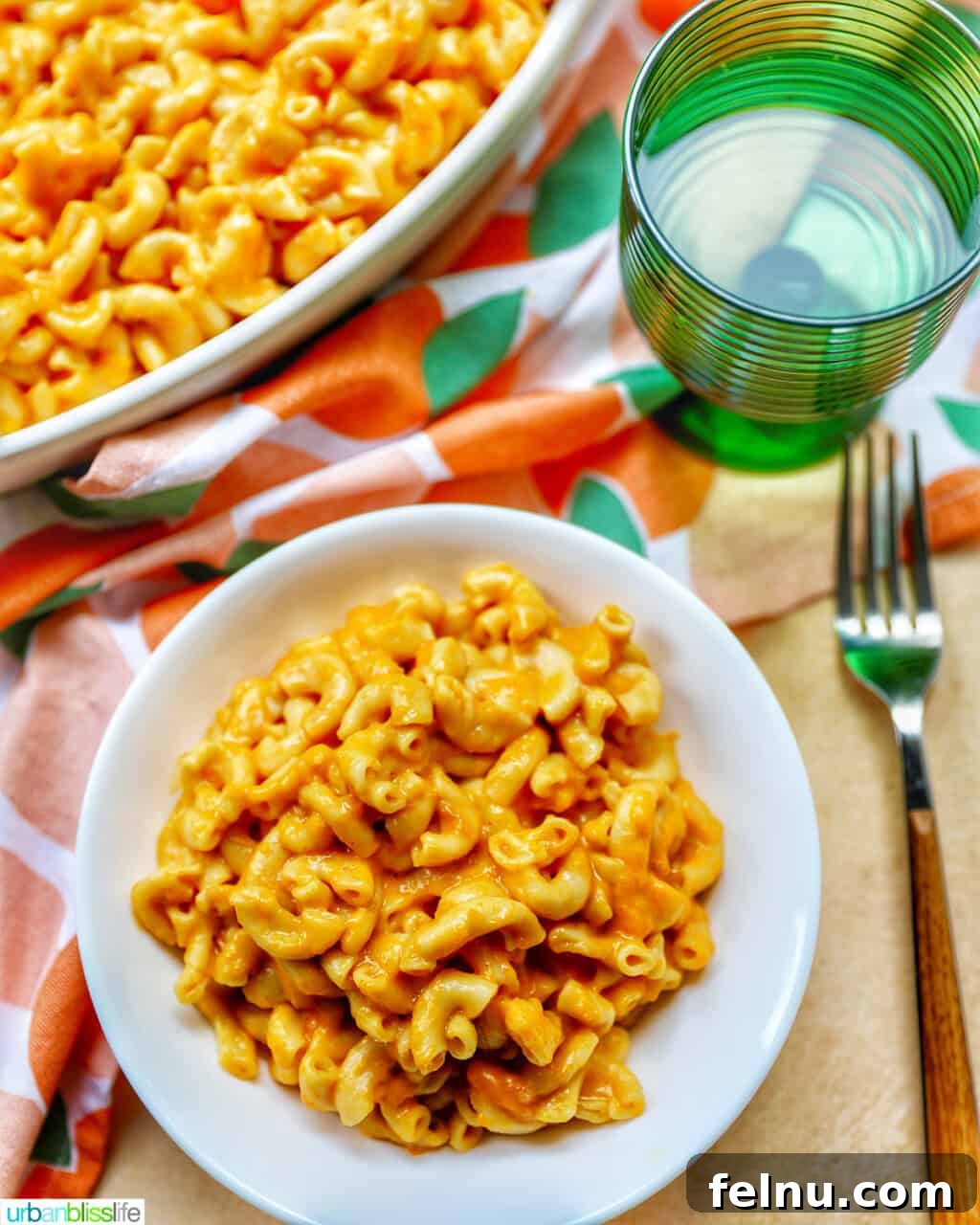 Savory Butternut Instant Pot Mac and Cheese 18 A bowl of creamy butternut squash mac and cheese alongside a glass of white wine, suggesting a sophisticated pairing.