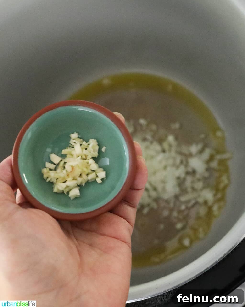 Savory Butternut Instant Pot Mac and Cheese 5 Adding minced garlic to the pressure cooker pot, joining the onions.
