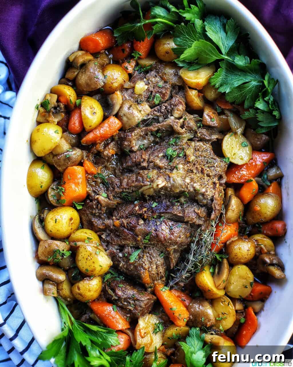 Succulent Dutch Oven Pot Roast 2 dutch oven pot roast with vegetables in a large white serving platter