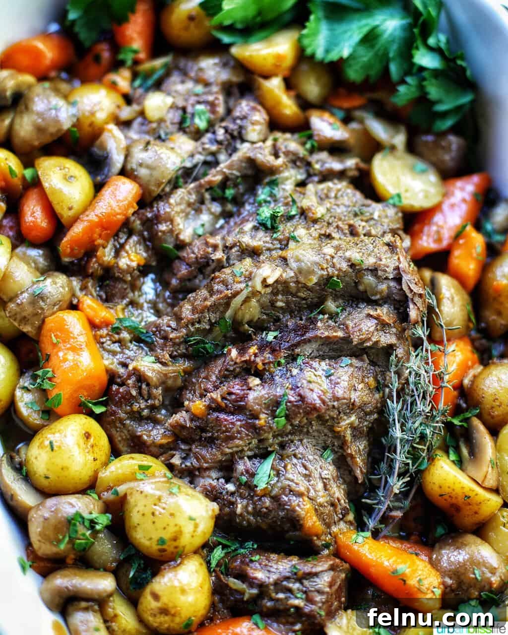 Succulent Dutch Oven Pot Roast 3 close up of dutch oven pot roast with vegetables in a large white serving platter