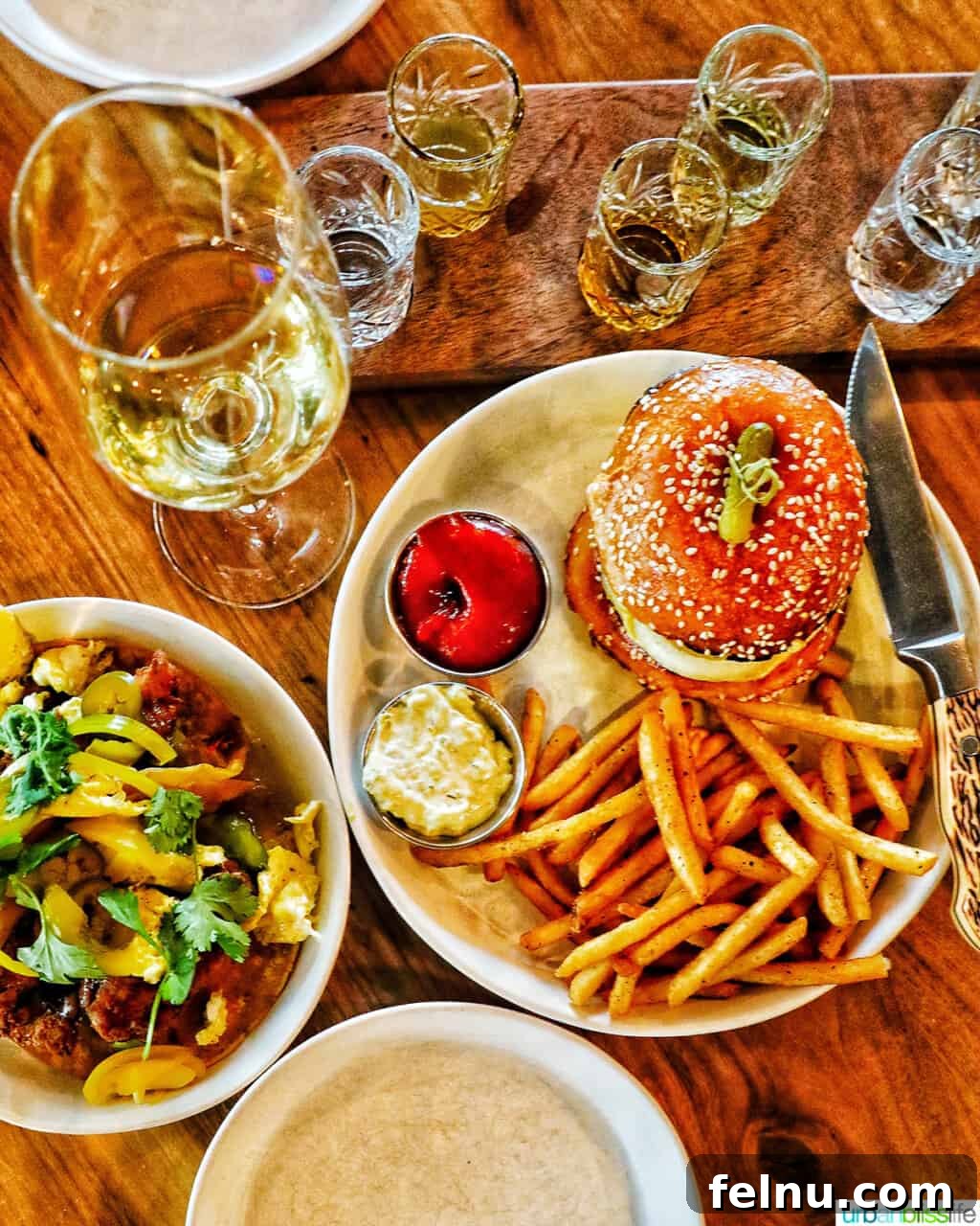 The Bullard Arms 3 A delicious spread at Bullard Tavern featuring crispy fried chicken tacos, a gourmet Bullard burger, and a refreshing glass of wine, showcasing the tavern's exquisite culinary offerings.