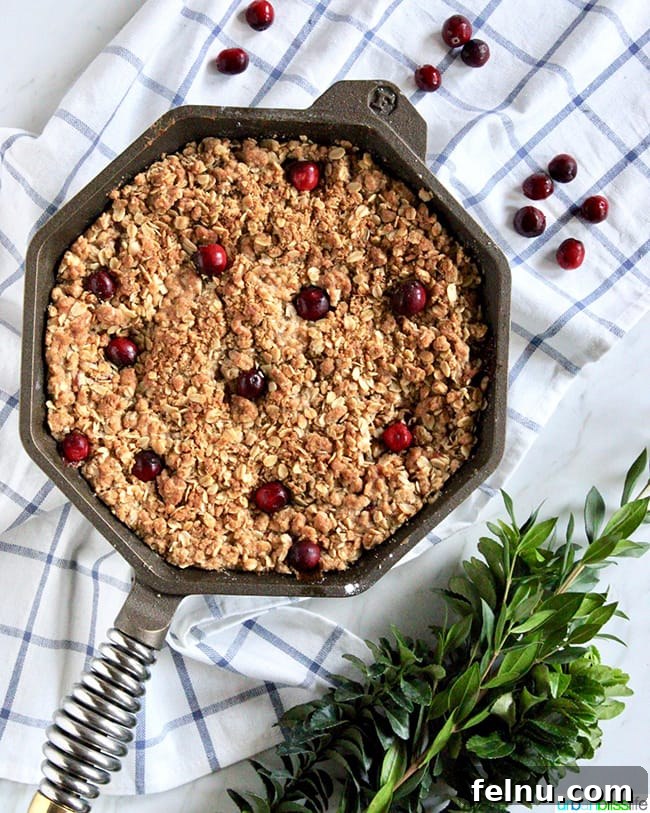 Skillet Apple Cranberry Crisp with a scoop removed.
