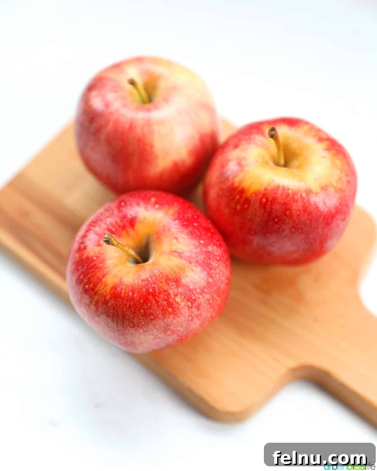 Fall's Apple Bounty: Sweet & Savory Recipes 3 three gala apples on a wood cutting board.