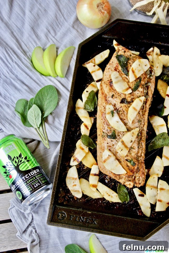 Grilled Pork Tenderloin with Hard Cider, Apples and Sage, served sliced.