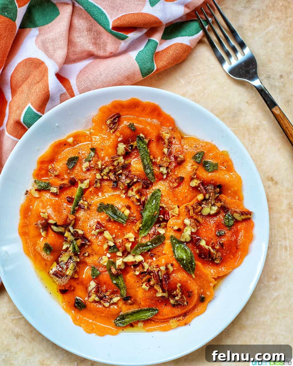 Butternut Squash Ravioli with Crispy Sage and Brown Butter Sauce in a white bowl with a fork, suggesting a delightful meal paired with wine.