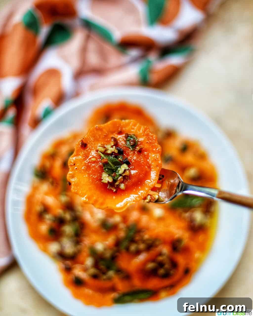 A forkful of Butternut Squash Ravioli with Crispy Sage and Brown Butter Sauce, showcasing the rich textures and flavors.