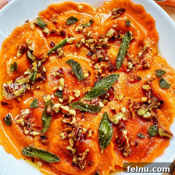 Butternut squash ravioli with brown butter sage sauce and herbs, presented attractively.