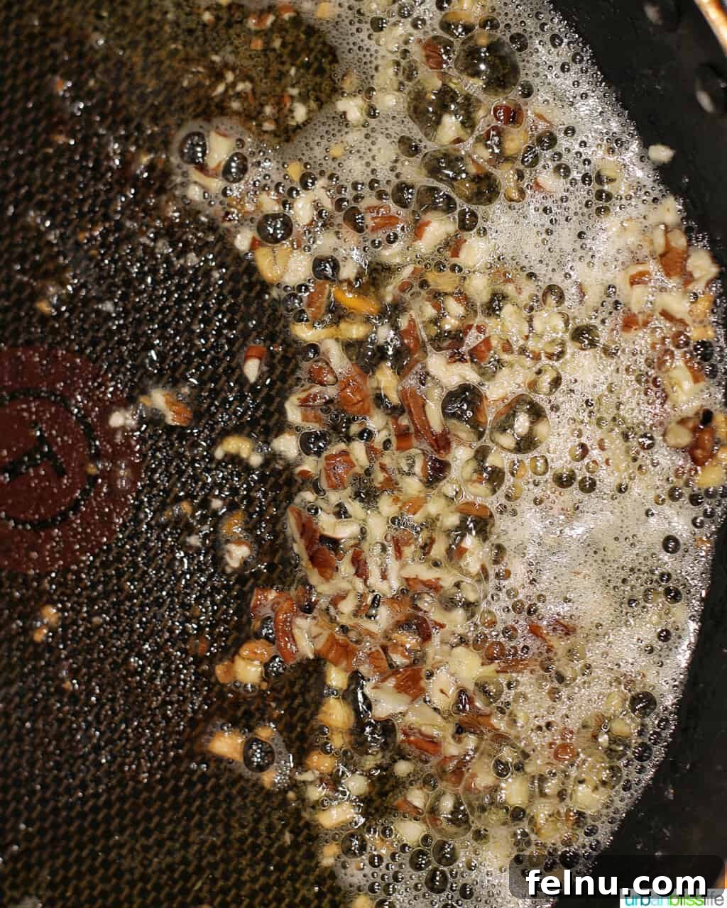 Chopped pecans sautéing alongside garlic in the rich brown butter sauce.