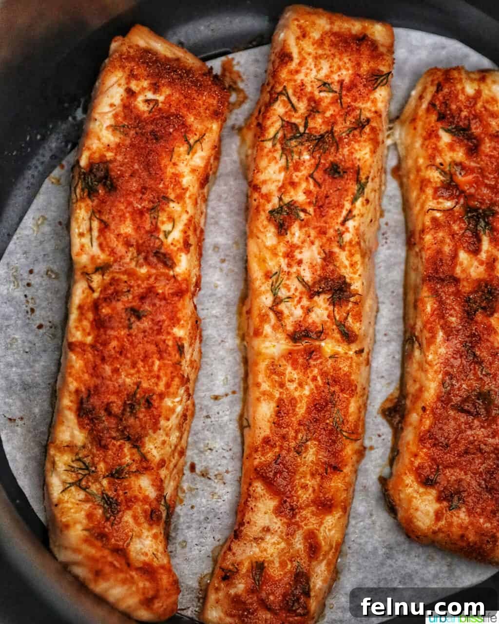 Perfect Air Fryer Salmon Every Time 13 Beautifully cooked salmon fillets in the air fryer, garnished with fresh dill.
