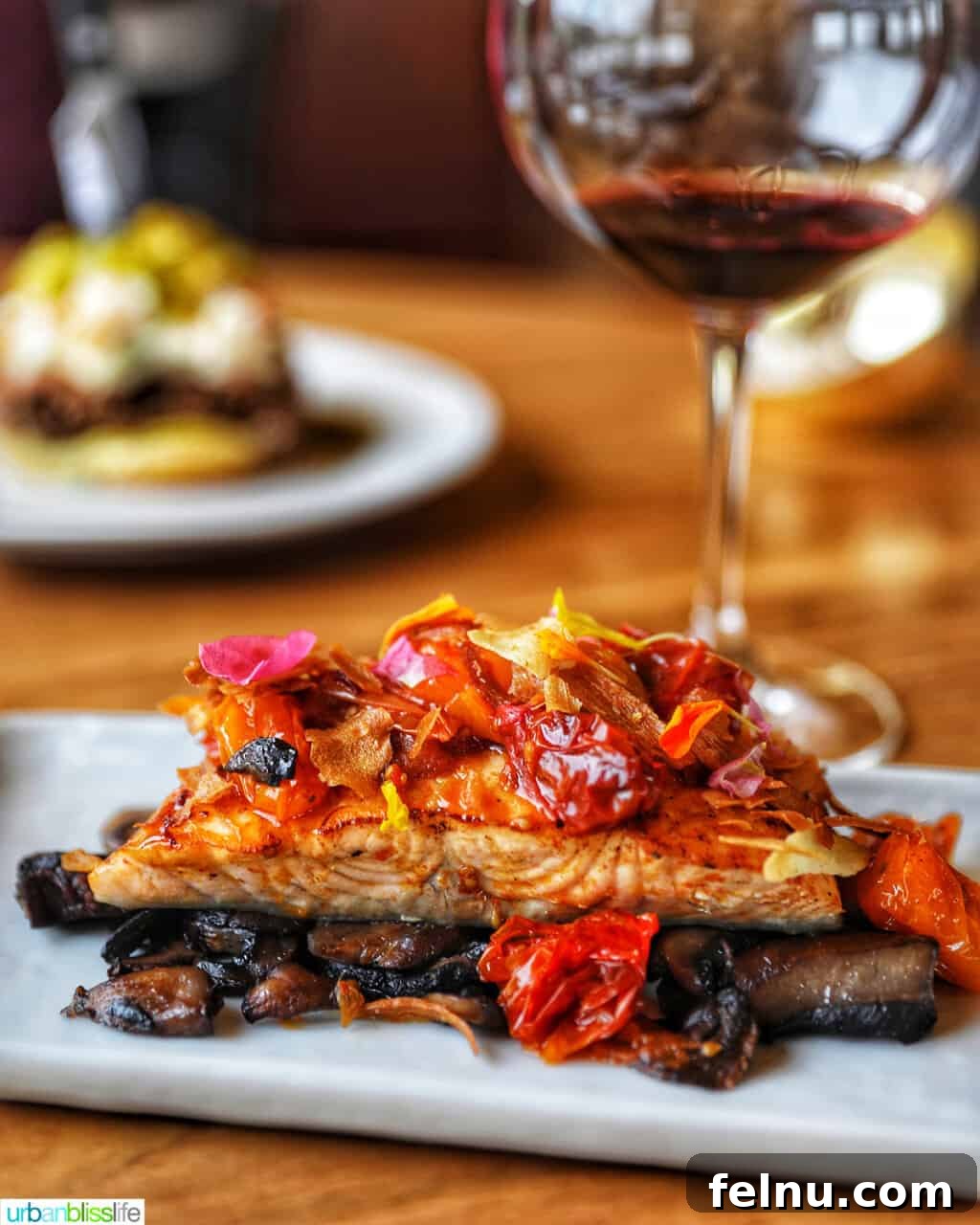 Perfect Air Fryer Salmon Every Time 16 A glass of red wine next to a plate of perfectly cooked salmon.