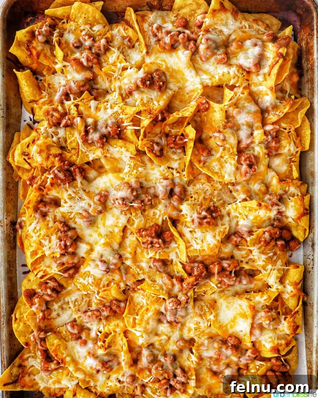 One-Pan Veggie Tex-Mex Nacho Fiesta 11 Baked vegetarian nachos filling an entire sheet pan, with melted cheese and seasoned beans