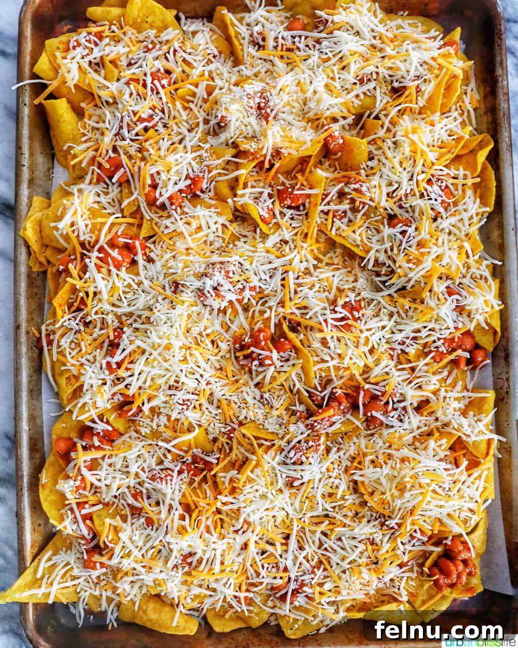 One-Pan Veggie Tex-Mex Nacho Fiesta 8 Adding Tex-Mex cheese blend over pinto beans and tortilla chips before baking