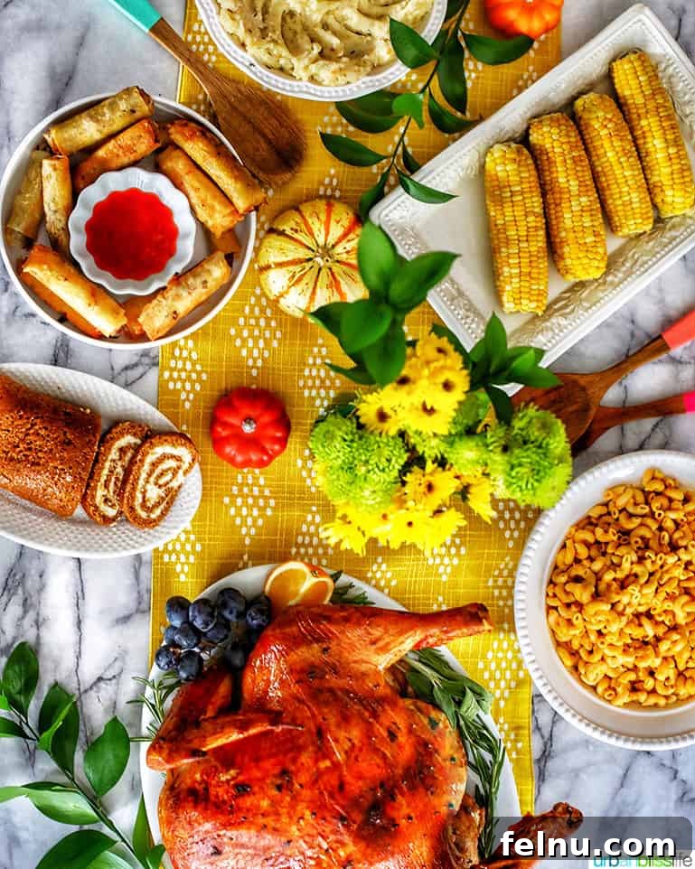 Thanksgiving table with turkey, mac and cheese, mashed potatoes, pumpkin roll, corn on the cob