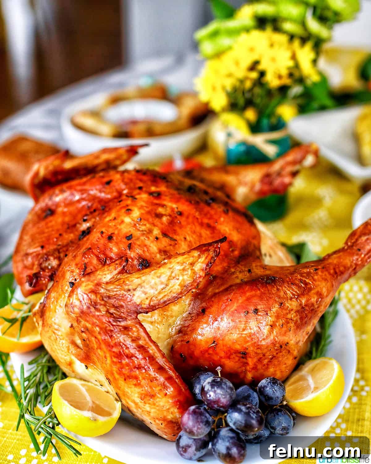 Thanksgiving turkey with grapes, herbs, and lemons on a Thanksgiving table.