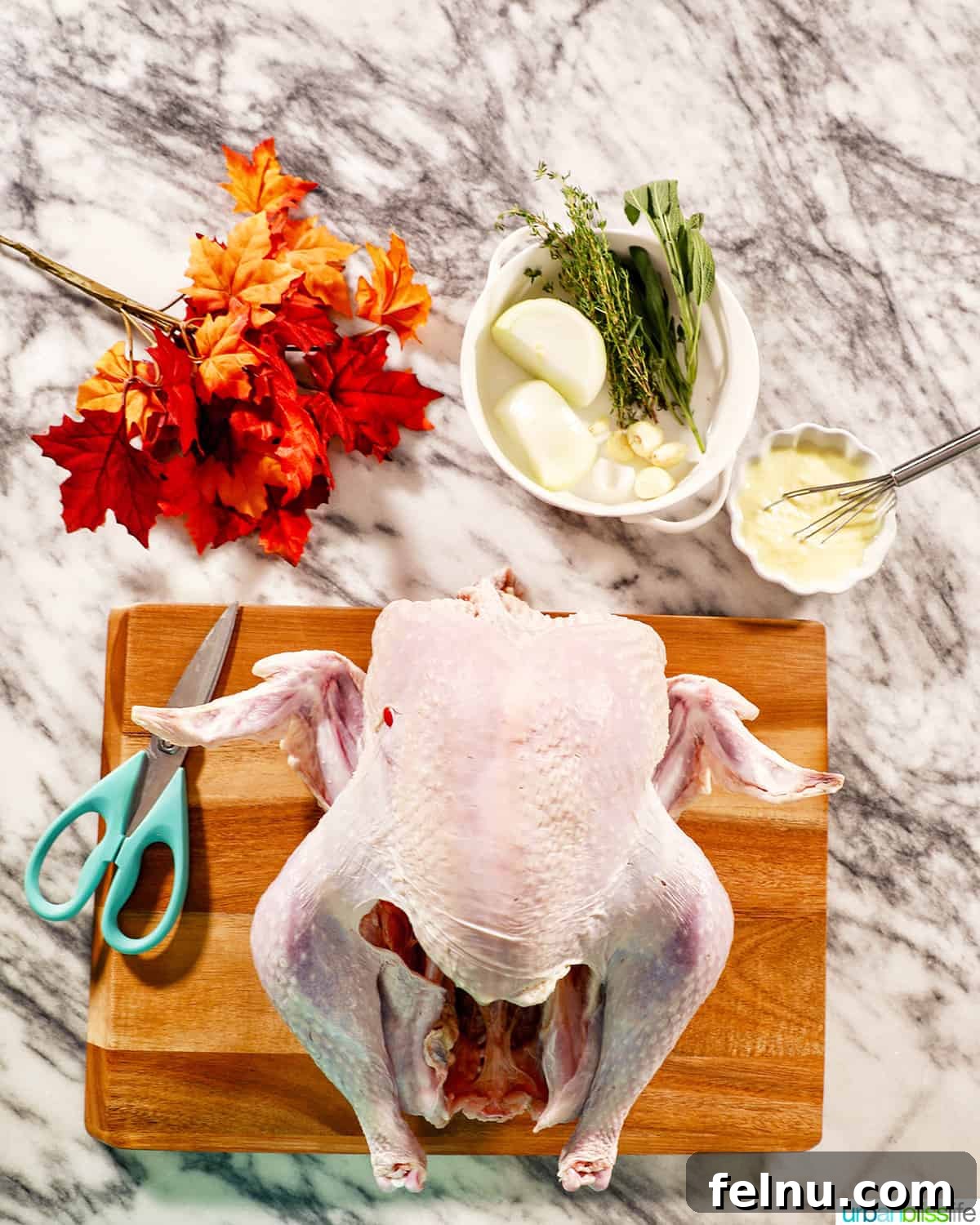 Preparing to spatchcock a turkey with kitchen shears on a cutting board.