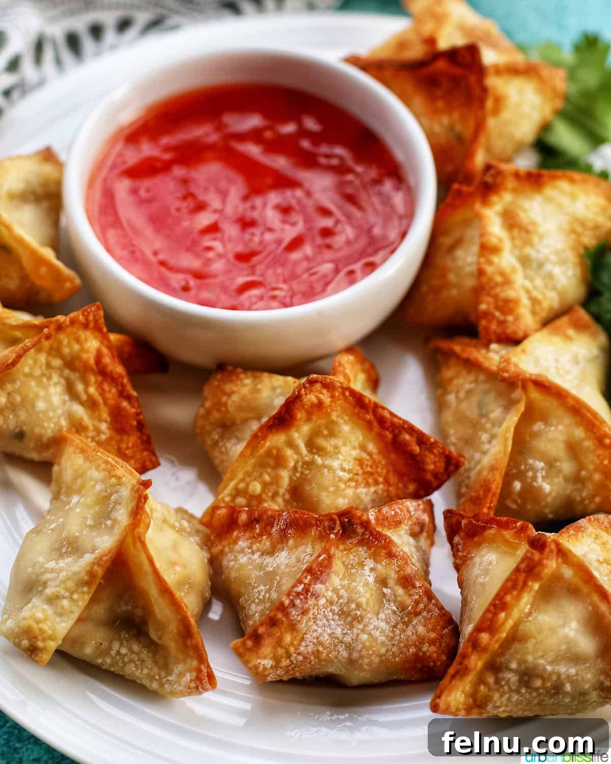 Perfectly Crispy Air Fryer Crab Rangoon 2 Crispy Air Fryer Crab Rangoon served on a plate with dipping sauce