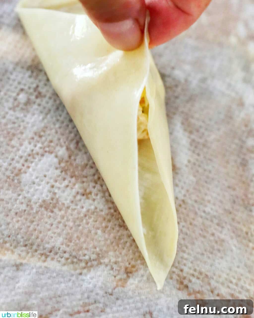 Perfectly Crispy Air Fryer Crab Rangoon 12 First fold of a crab rangoon wonton, bringing two corners together