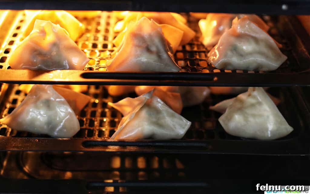 Perfectly Crispy Air Fryer Crab Rangoon 17 Crab rangoons cooking in an air fryer basket