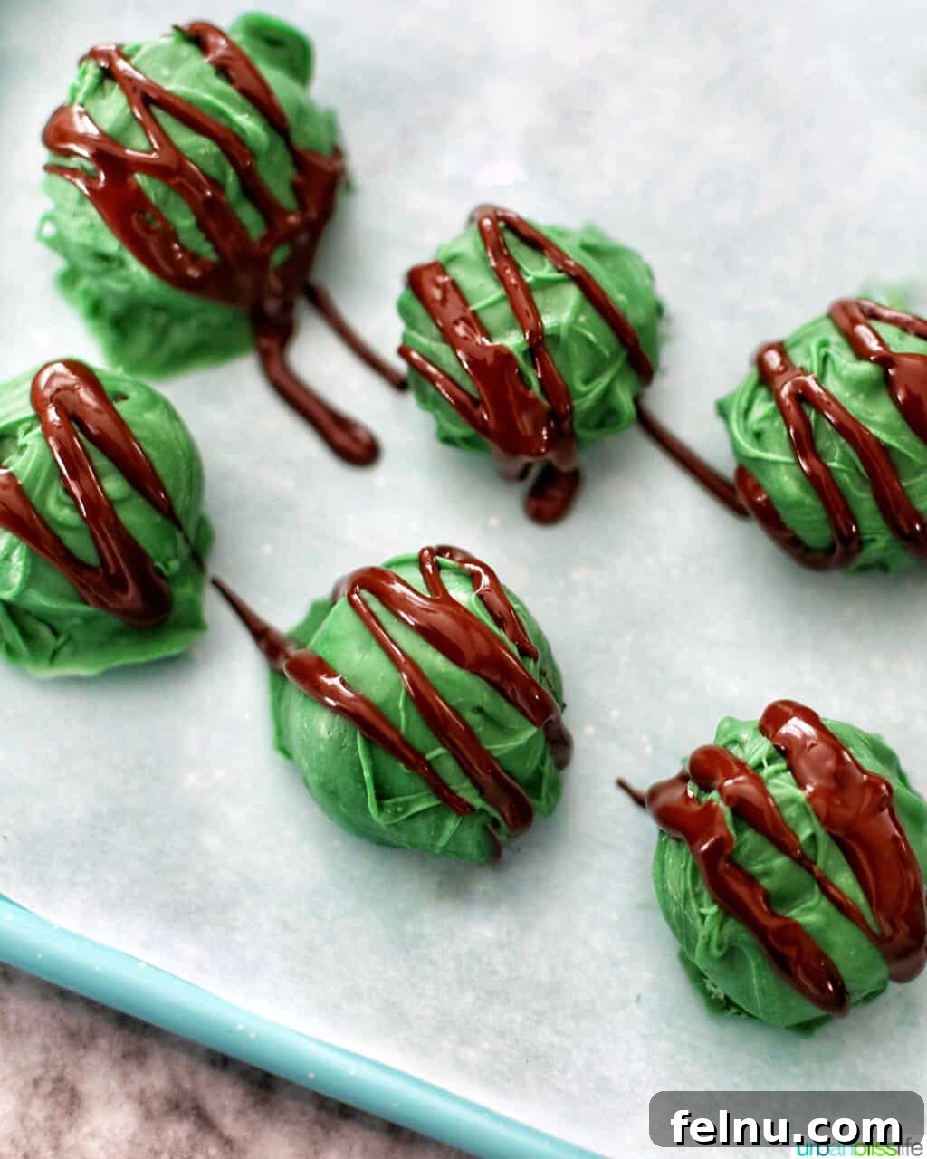 Mint Oreo Bliss Bites 3 Close-up of green Mint Oreo Truffles with chocolate drizzle.