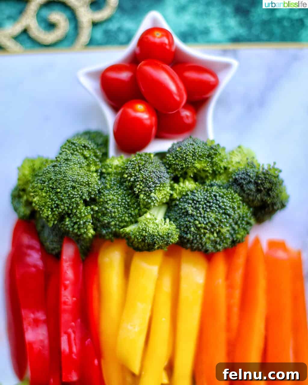 Christmas Tree Vegetable Platter 6 Tomatoes, broccoli, and bell peppers arranged on the veggie tray