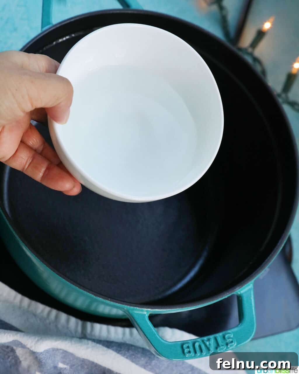 Effortless Simple Syrup: Sweeten Anything 6 Pouring fresh water into a clean pot on the stove, beginning the simple syrup preparation.