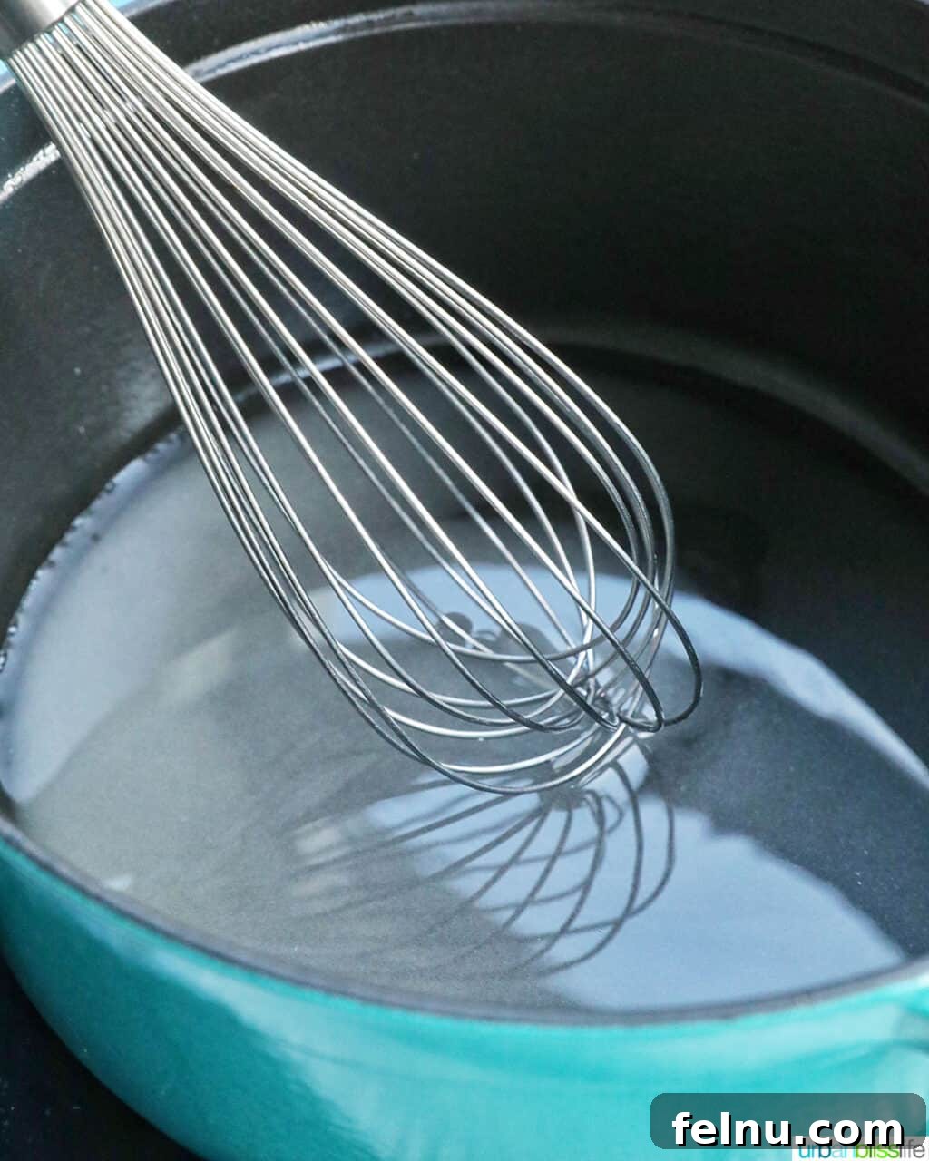 Effortless Simple Syrup: Sweeten Anything 8 Whisking the simple syrup mixture vigorously in a pot to ensure all sugar dissolves, creating a clear liquid.