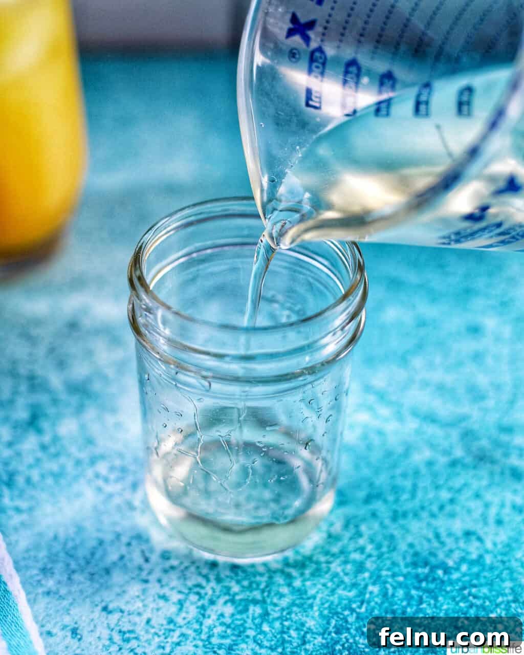 Effortless Simple Syrup: Sweeten Anything 9 Pouring freshly made simple syrup into a glass jar for storage, a vital step after cooling.