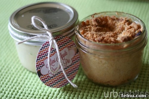 Freshly baked mini pies in jars, arranged appealingly on a wooden surface.